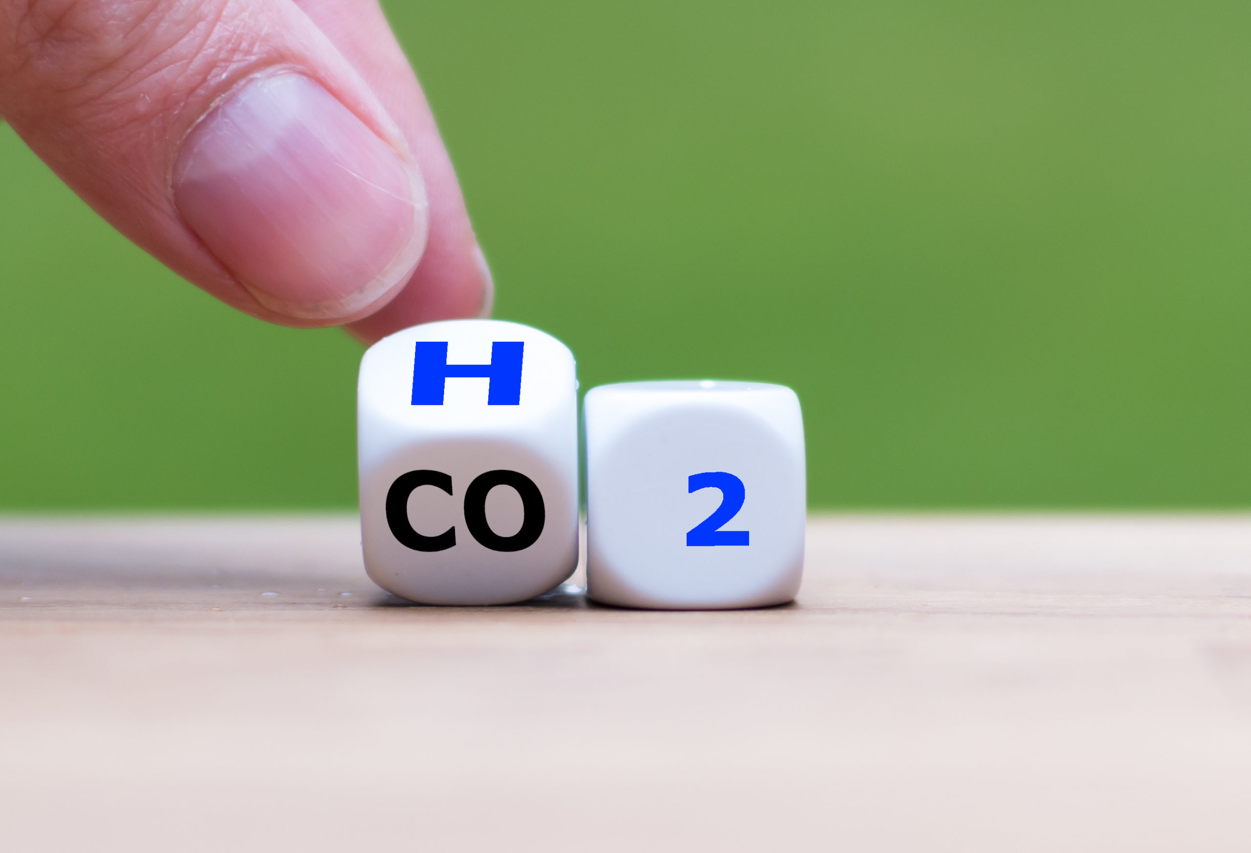 Change to fuel cell vehicles. Hand flips a dice and changes the expression CO2 to H2 / AdobeStock/Patrycja Rapacka